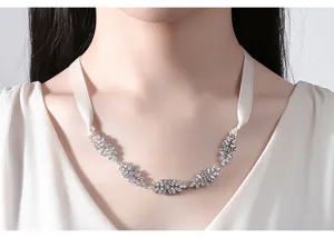 Elegante collana da sposa in zirconia con nastro bianco sul collo di una modella.