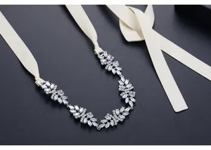 Dettaglio di collana da sposa in zirconi con eleganti nastri di raso color crema