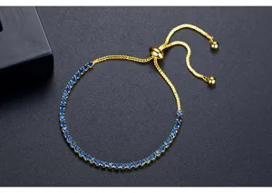Vista detallada de pulsera ajustable dorada con piedras de circonita azul brillantes