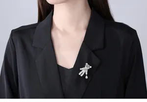 Detailed shot of a sparkling silver teddy bear brooch pinned on an elegant black blazer lapel