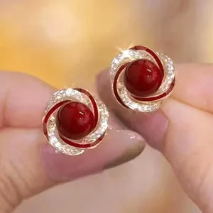 Close-up of elegant French retro flower ball stud earrings with red beads and stones
