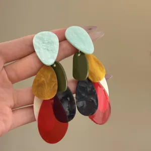 Detailed macro view of vibrant dopamine colored multi-layer acrylic teardrop earrings