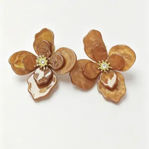 Detailed macro view of elegant brown resin floral earrings with gold stamen and crystal center
