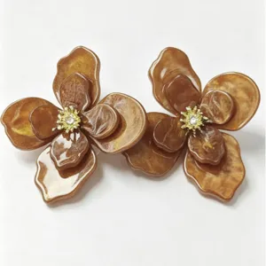 Close-up of brown marbled flower stud earrings with golden rhinestone centers