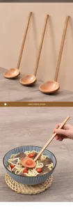 Detailed view of a long-handle wooden ramen spoon used in a bowl of ramen noodles