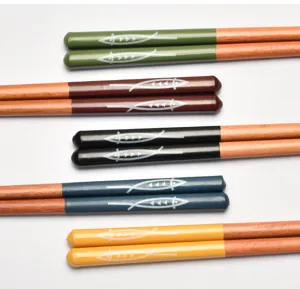 Detalle de palillos de madera japoneses con coloridos motivos de peces lacados