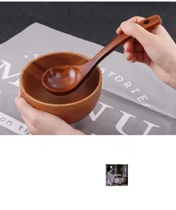 Gedetailleerde weergave van een handgemaakte houten soeplepel en kom set in gebruik