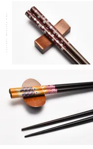 Close-up detail of Japanese wooden chopsticks featuring cherry blossom and fish patterns