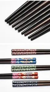 Detailed view of Japanese wooden chopsticks with floral and fish pattern handles
