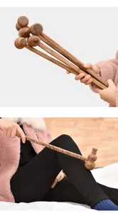 Close-up of natural wenge wood massage hammer being used for leg meridian tapping