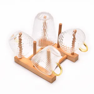 Textured glass cups with gold handles on bamboo storage rack for kitchen drying display