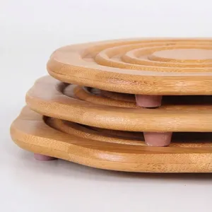 Close-up of stacked natural bamboo heat insulation pads with pink anti-slip feet
