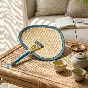 Traditional hand-woven wheat straw palm leaf fan with elegant blue fabric border for summer