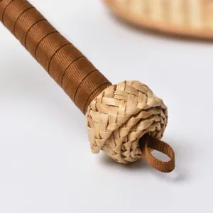 Handcrafted wheat straw fan handle detail with brown ribbon wrap and woven knot
