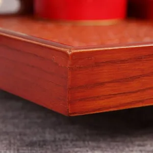 Close-up of reddish-brown wooden tray corner showing fine wood grain and joinery.