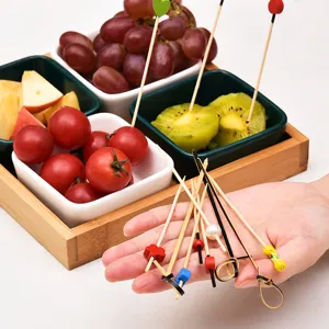 Dekorative Bambus-Fruchtspieße mit bunten Blumenknoten für Cocktailsnacks und Vorspeisen.