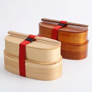 Dubbellaagse houten Japanse bento lunchbox met eetstokjes en rode elastische band
