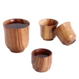 Natural handcrafted acacia wood Japanese sake and tea cups displayed on white background