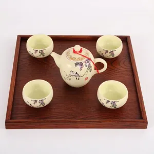Square dark wood serving tray with decorative ceramic tea set on white background