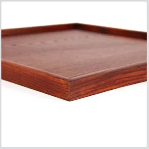 Macro detail of a square reddish-brown wooden serving tray with visible natural grain