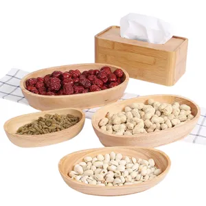 Set of 4 oval boat-shaped wooden snack bowls filled with assorted nuts and dried fruits.