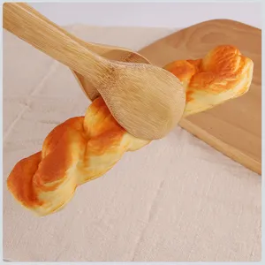 Natural bamboo food tongs gripping twisted bread for baking, BBQ, and buffet service