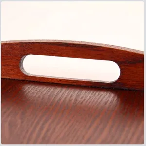 Primer plano de un asa de bandeja de madera oscura con textura de veta natural.