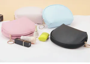 Detail shot of four colorful semi-circle waterproof cosmetic bags with daily makeup props