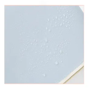 Close-up detail showing the waterproof texture and droplets on the light blue travel bag