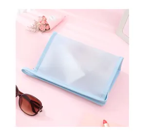 Detailed view of a light blue frosted PVC waterproof makeup bag with a handle on pink background