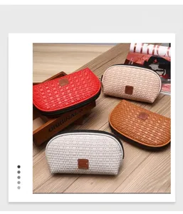 Gruppo di quattro borse cosmetiche intrecciate in rosso, beige, marrone e bianco