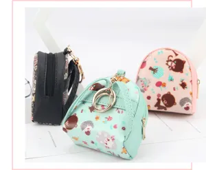 Detailed view of mini shell-shaped cartoon coin purses featuring elegant golden keychains