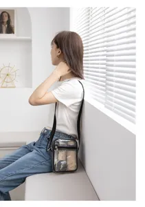 Detailed view of a transparent PVC crossbody bag worn by a model in a bright room