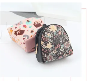 Close-up of mini floral and cartoon shell coin purses with secure gold-tone zippers.