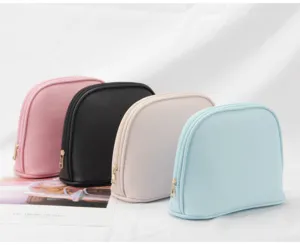 Close-up of four colorful shell-shaped waterproof travel cosmetic bags with gold zippers.