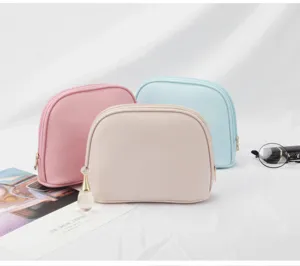 Three pastel-colored waterproof shell cosmetic bags for travel storage