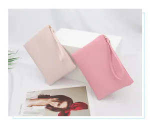 Close-up of two pink waterproof PU leather cosmetic pouches with gold zippers and wristlets