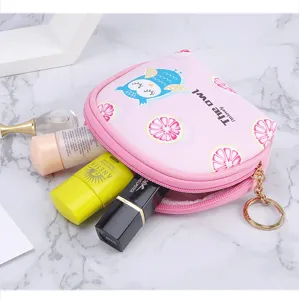 Macro view of the pink owl mini storage pouch shown with various cosmetic products inside