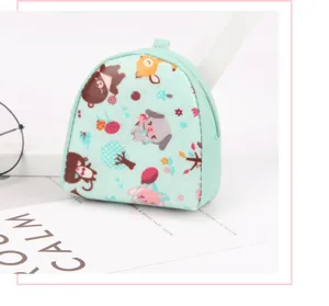 Close-up detail of a mint green cartoon coin purse with floral patterns and zipper closure