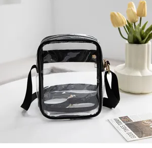 Detailed view of a transparent PVC crossbody bag with black strap on a minimalist table set