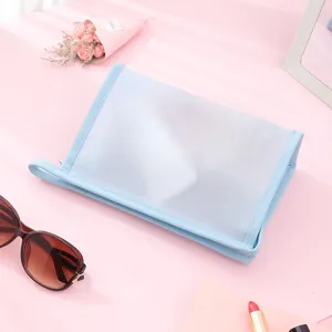 Minimalist frosted PVC waterproof makeup bag with light blue trim and side handle strap