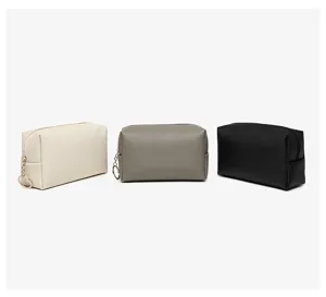 Three rectangular textured PU leather makeup bags in off-white, grey, and black colors