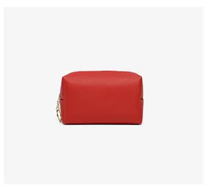 Close-up of a red textured PU leather cosmetic bag with a gold zipper ring.