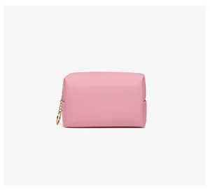 Close-up of pink PU leather makeup bag with gold ring zipper and cross-hatch texture