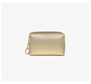 Macro view of gold textured PU leather makeup bag with circular metal zipper pull