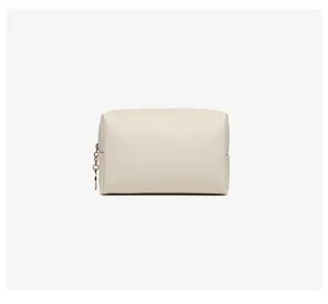 Close-up of minimalist cream PU leather square cosmetic bag with gold chain zipper