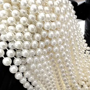 Close-up detail of 10mm white imitation pearl bead strands for DIY wedding decor.