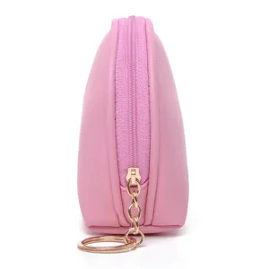 Side profile of a pink shell-shaped waterproof cosmetic pouch with gold zipper detail