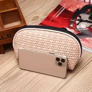 Grande borsa da trucco intrecciata rosa con cerniera mostrata con telefono per scala