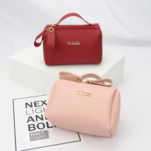 Two stylish portable red and pink faux leather cosmetic makeup bags with golden KUOY logo